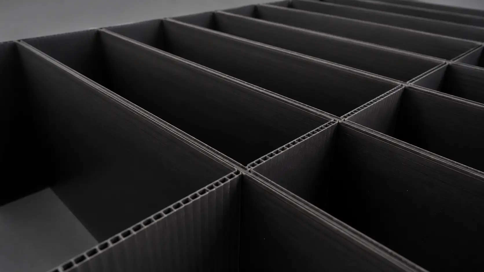 Close-up of black corrugated plastic panels forming a grid of rectangular compartments