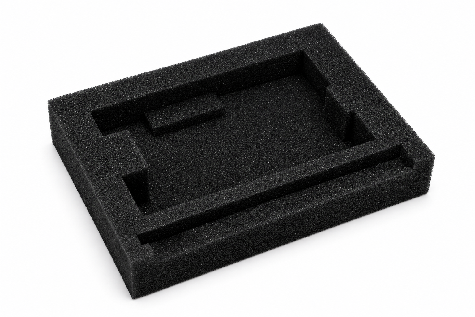 Black foam packaging insert with internal cutouts for securing components, viewed from an angled perspective.
